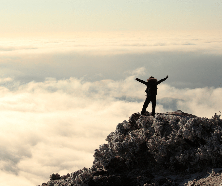 Person at the top of a mountain celebrating