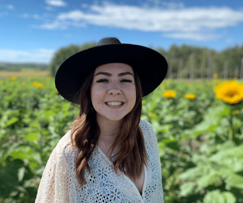 Rachael smiling in a field of sunflowers