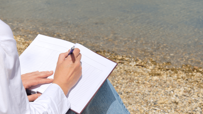 A woman journaling by a lake