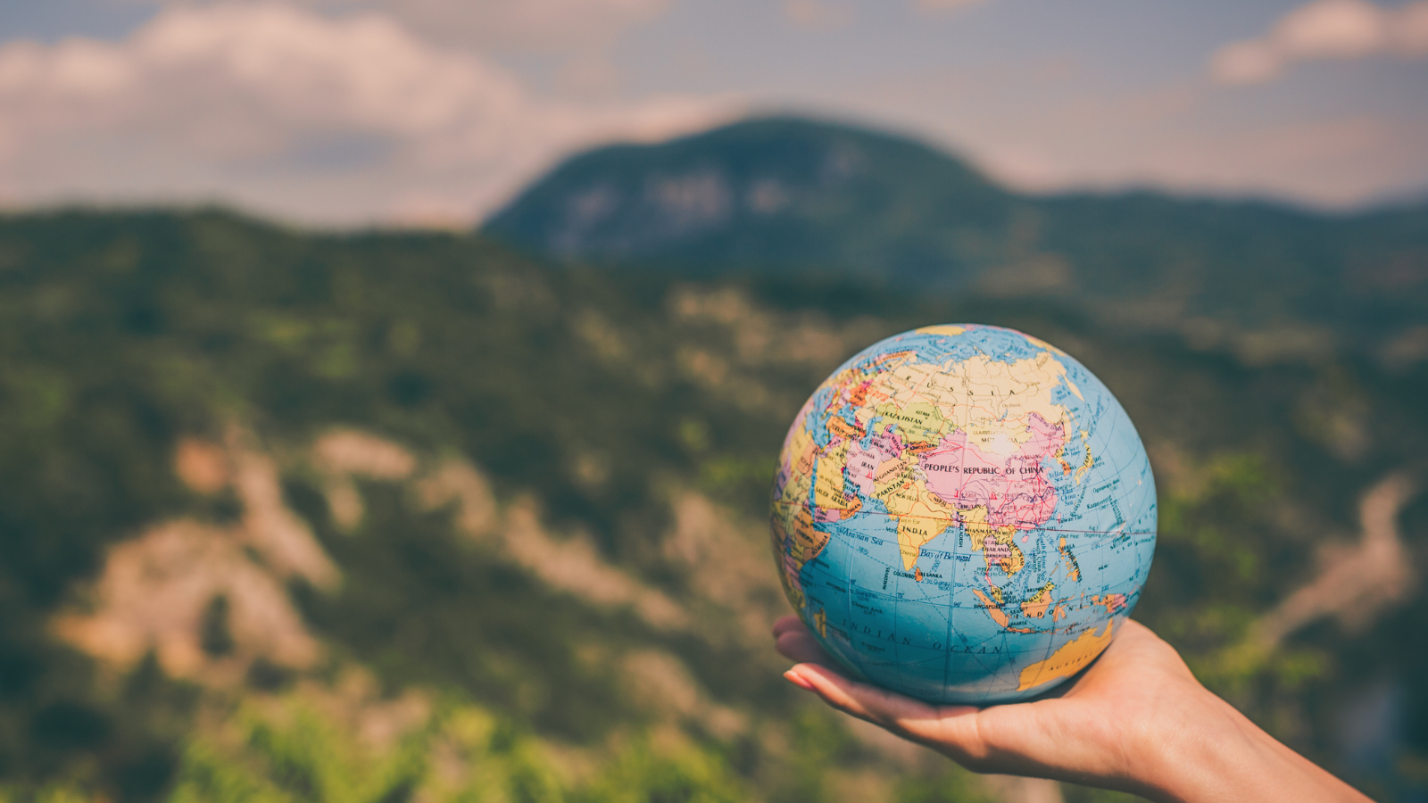 A person holding a miniature version of planet earth